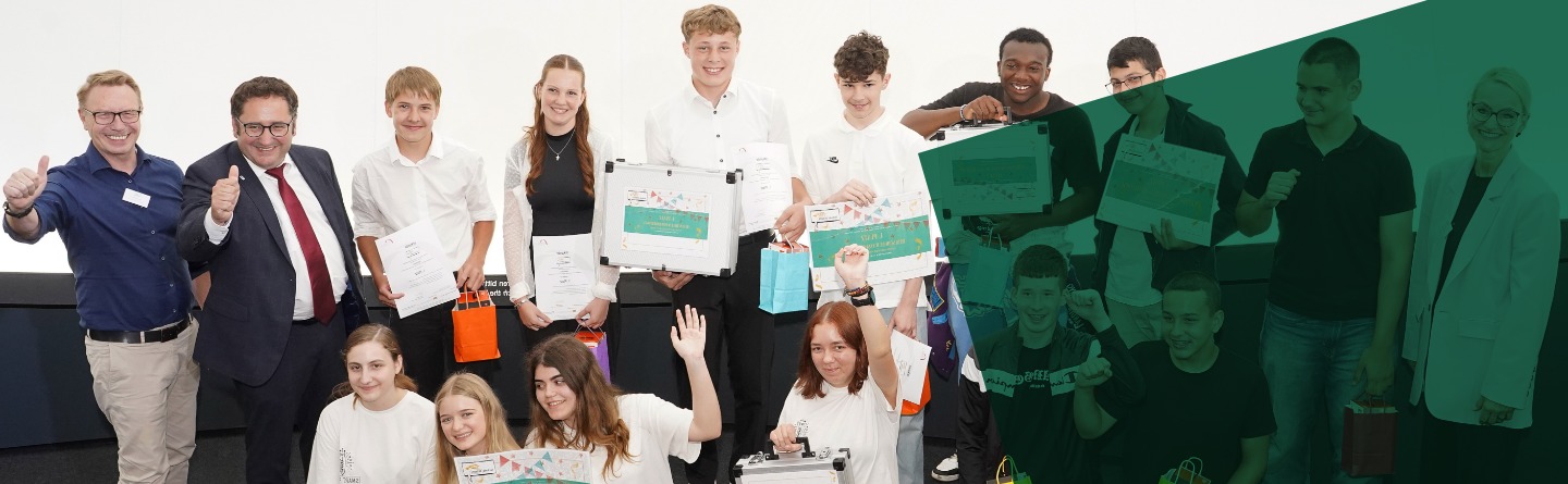 Eine Gruppe von Schülern und Erwachsenen, die Plakate in der Hand halten und für ein Foto posieren