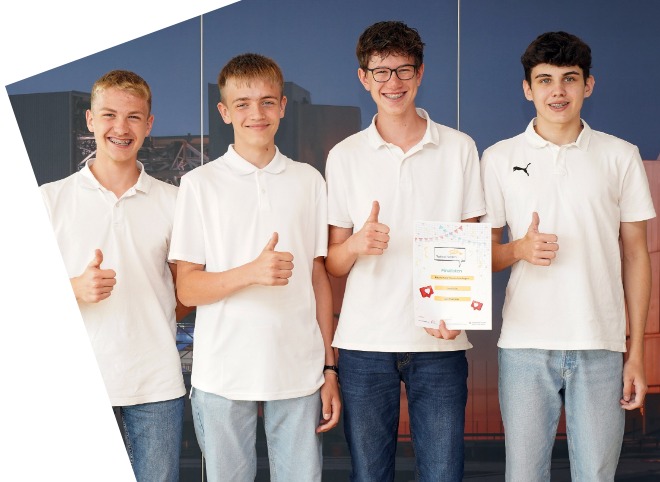 Vier Schüler, vor einer blauen Wand, die für ein Foto posieren