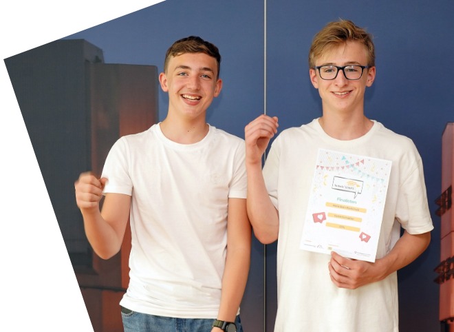 Zwei Schüler, vor einer blauen Wand, die für ein Foto posieren