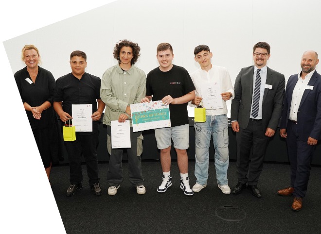 Die Gewinner des Bestpreises der Mittelschulen Vier Schüler, die Plakate in der Hand halten und mit drei Erwachsenen für ein Foto posieren