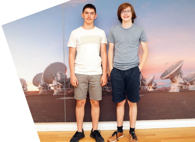 Abschlussveranstaltung 2023 Zwei Schüler, vor einer blauen Wand, die für ein Foto posieren
