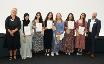 Die Gewinnerinnen des Kreativpreises Sechs Schülerinnen, die Plakate in der Hand halten und mit zwei Erwachsenen für ein Foto posieren